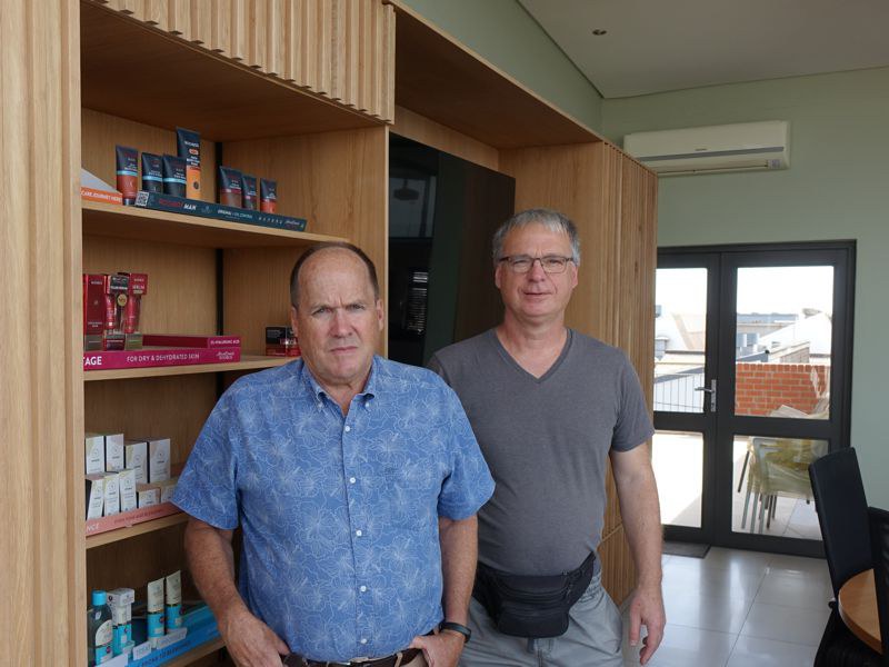 Rob Tiffin steht mit dem Shopbetreiber im Büro von African Extracts in Kapstadt.