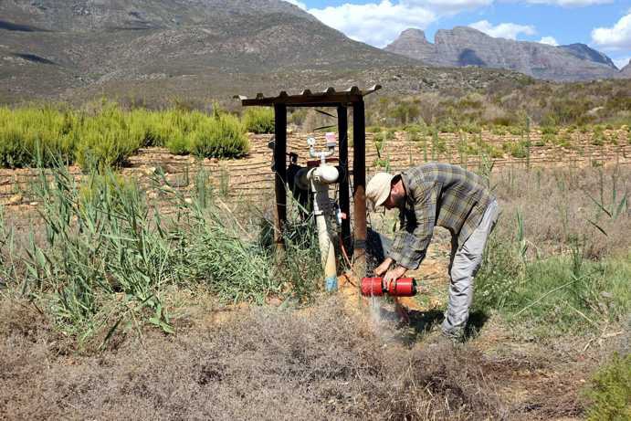 Sand filter maintenance; irrigation supplied by a natural rainwater dam.